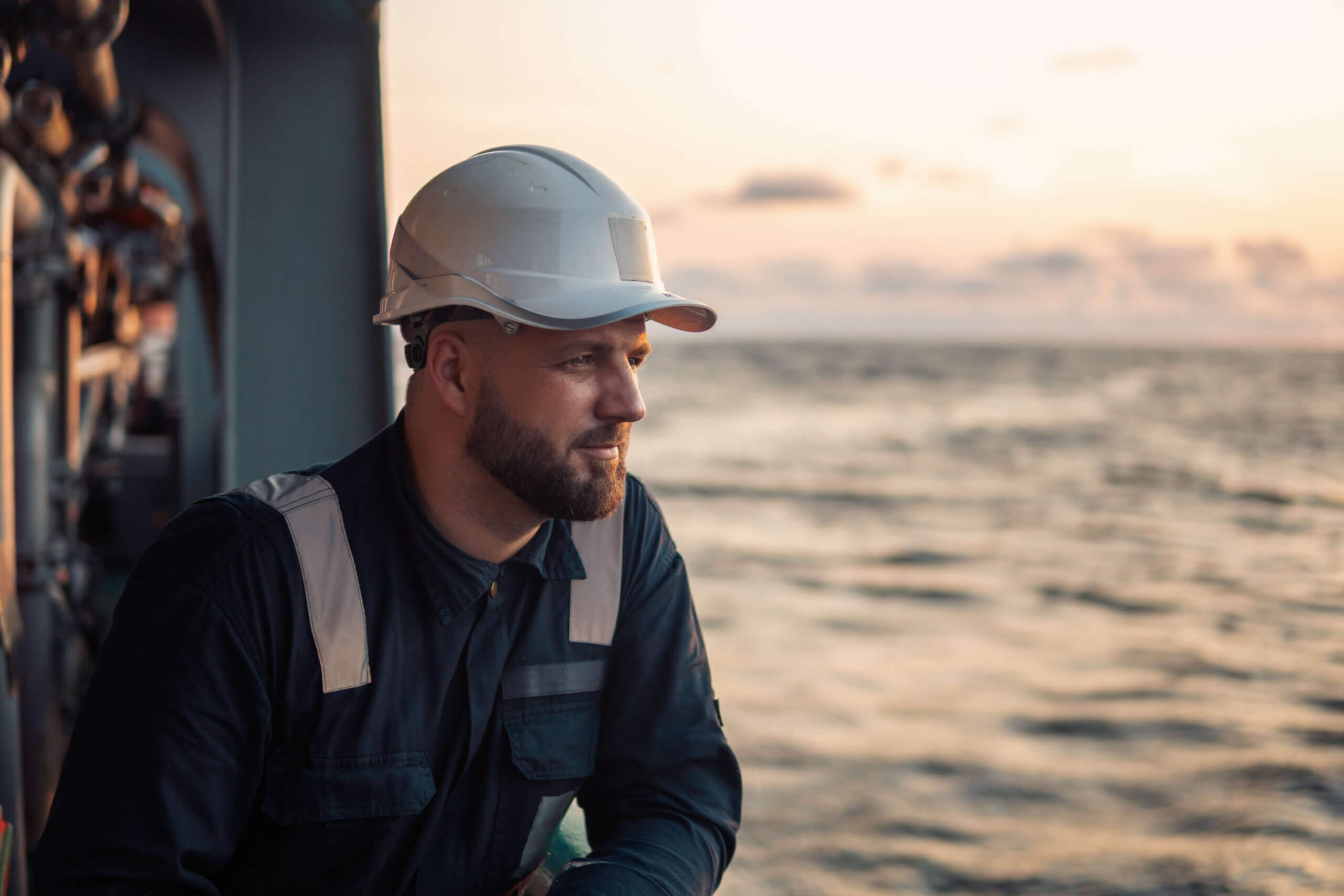 An offshore worker gazing at the sea during sunset
